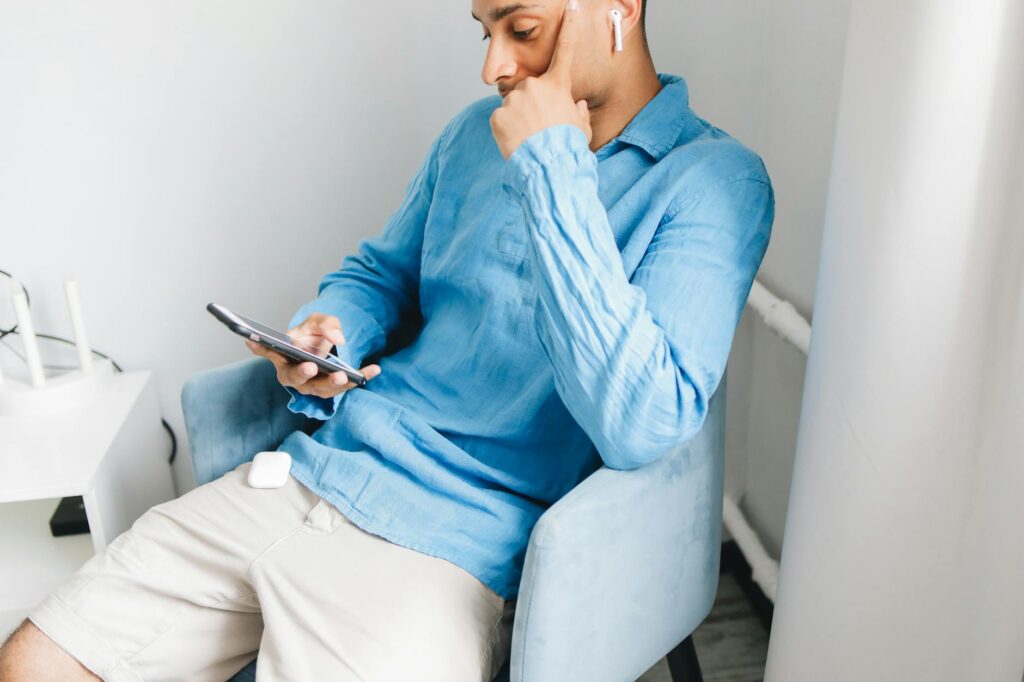 一人暮らしの部屋でワイヤレスイヤホンを使う様子