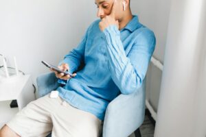 一人暮らしの部屋でワイヤレスイヤホンを使う様子